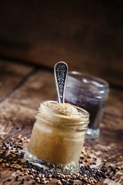 Mustard in a glass jar and seeds black and yellow — Stock Photo, Image