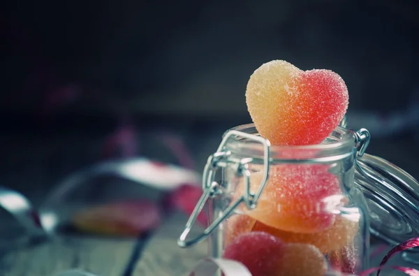 Fruit jelly hearts in a glass jar — Stock Photo, Image