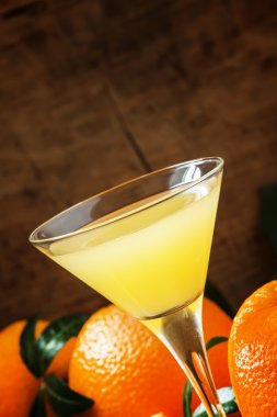 Yellow cocktail with orange juice in a martini glass