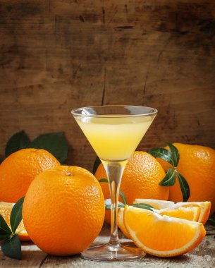 Yellow cocktail with orange juice in a martini glass
