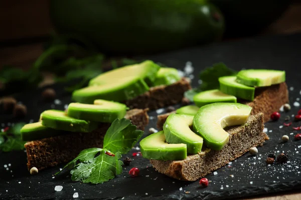 Panini con avocado, pane nero di segale e spezie — Foto Stock