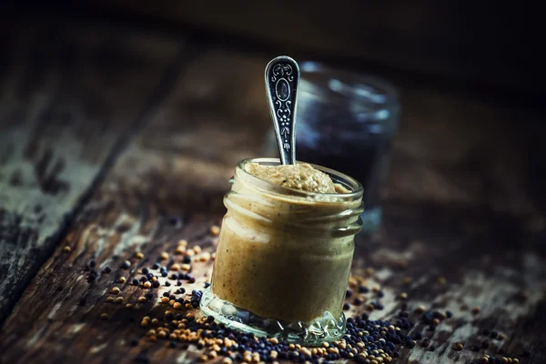 Гірчиця в скляній банці і насіння чорно-жовте — стокове фото