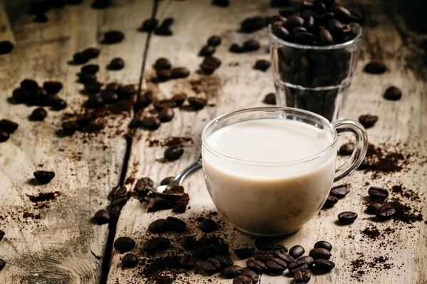 Скляна чашка кави з молоком, розлитим зерном і меленою кавою — стокове фото
