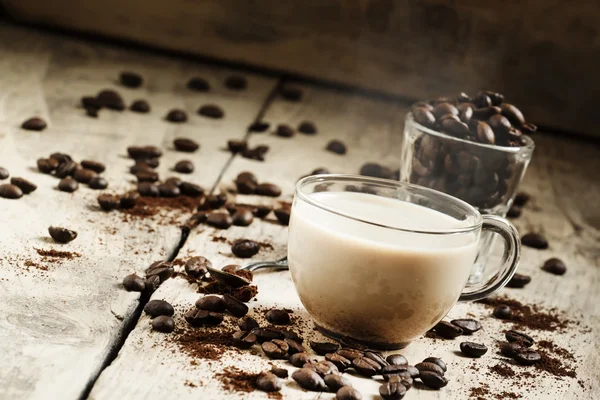 Glas kopp kaffe med mjölk, utspilld säd och kaffe — Stockfoto