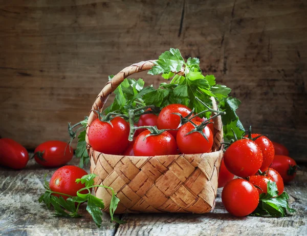 Cherry tomatoes and parsley in wicker basket — Stock Photo, Image