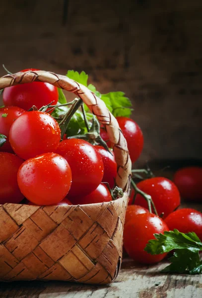 Pomodori ciliegia e prezzemolo in cesto di vimini — Foto Stock