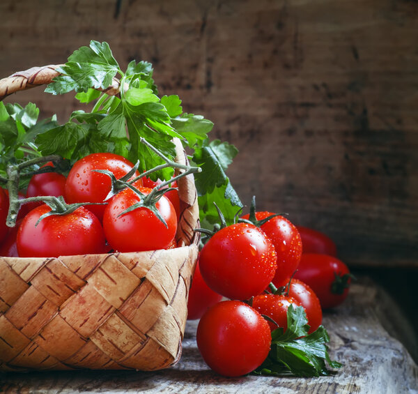 Cherry tomatoes and parsley in wicker basket 
