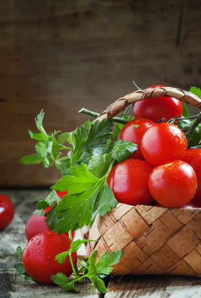 Cherry tomatoes and parsley in wicker basket — Stock Photo, Image