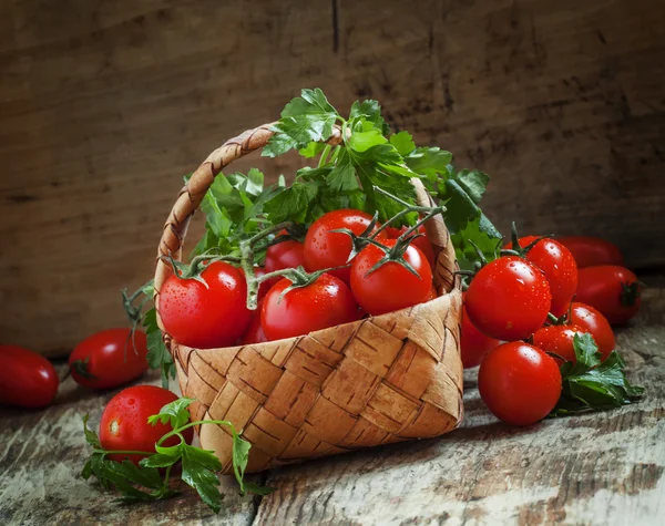 Pomodori ciliegia e prezzemolo in cesto di vimini — Foto Stock