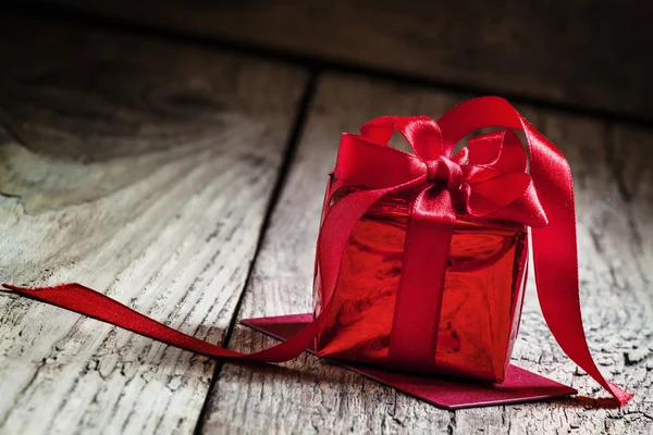 Caja de regalo roja atada con una cinta escarlata con lazo —  Fotos de Stock