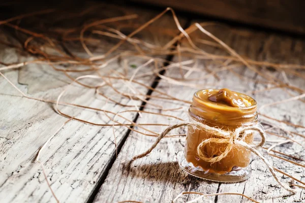 Soft homemade caramel in a glass jar — Stock Photo, Image