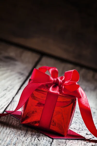 Caja de regalo roja atada con una cinta escarlata con lazo —  Fotos de Stock