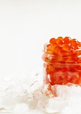 Kırılmış buz üzerinde cam kavanozda kırmızı somon havyar  