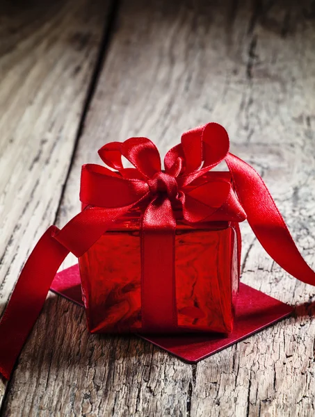 Caja de regalo roja atada con una cinta escarlata con lazo —  Fotos de Stock