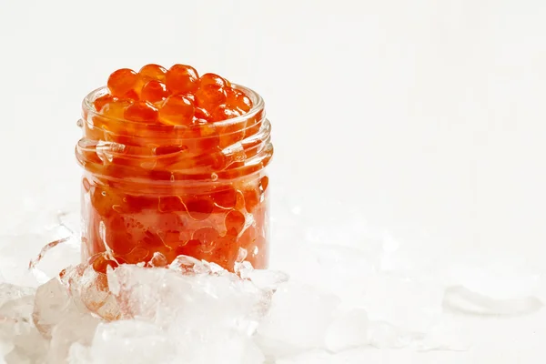 Red salmon caviar in a glass jar — Stock Photo, Image