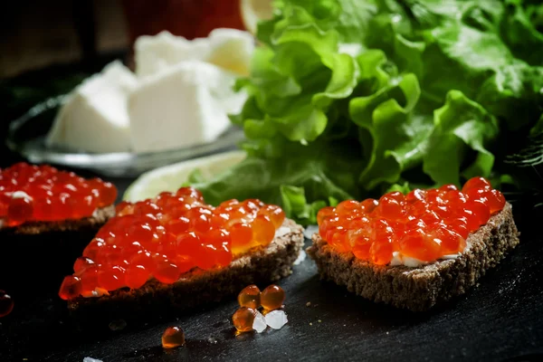 Sandwiches met zwart roggebrood, boter en kaviaar van rode zalm — Stockfoto