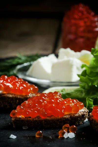 Sandwiches con pan de centeno negro, mantequilla y caviar de salmón rojo — Foto de Stock