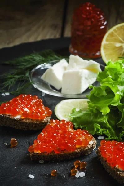 Sandwiches con pan de centeno negro, mantequilla y caviar de salmón rojo —  Fotos de Stock