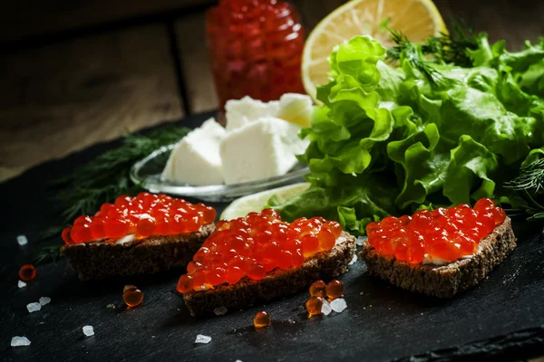 Siyah çavdar ekmeği, tereyağı ve kırmızı somon havyar ile Sandviçler 
