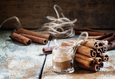 Ground cinnamon, cinnamon sticks, tied with jute rope  