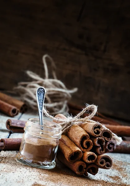 Canela moída, paus de canela, amarrados com corda de juta — Fotografia de Stock