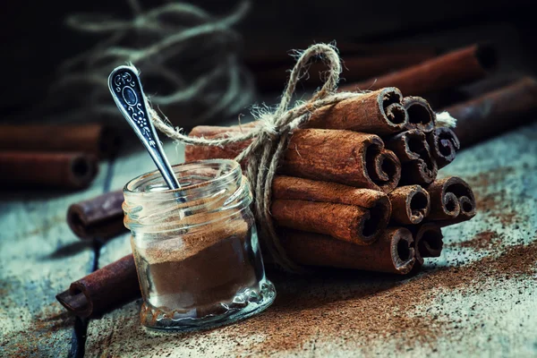 Canela moída, paus de canela, amarrados com corda de juta — Fotografia de Stock