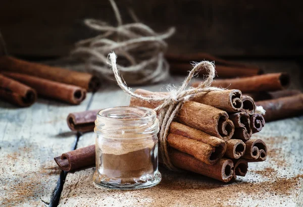 Canela moída, paus de canela, amarrados com corda de juta — Fotografia de Stock