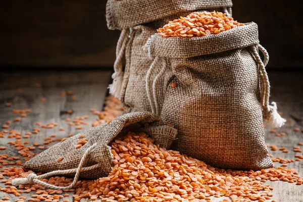 Red lentils in a burlap bags — Stock Photo, Image