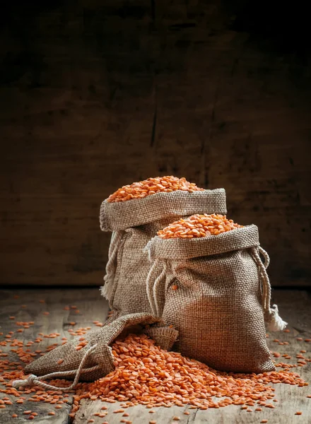 Lentilhas vermelhas em sacos de serapilheira — Fotografia de Stock