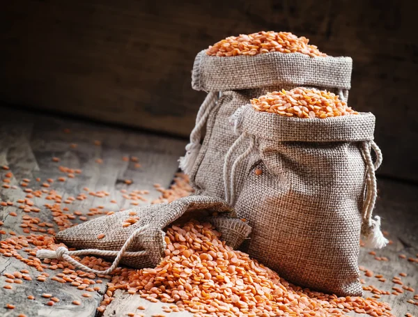 Red lentils in a burlap bags — Stock Photo, Image