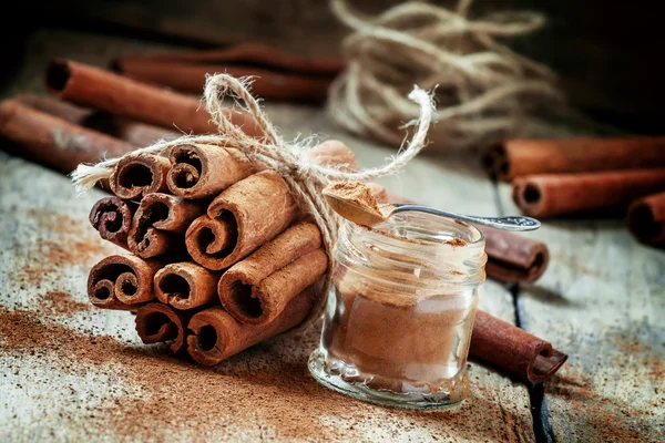 Cannelle moulue, bâtonnets de cannelle, attachés avec une corde de jute — Photo