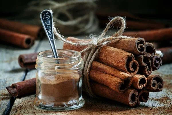 Cannelle moulue, bâtonnets de cannelle, attachés avec une corde de jute — Photo