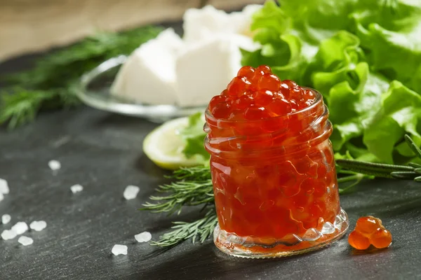 Красная икра с салатом, укропом, розмарином, лимоном, морской солью и маслом — стоковое фото