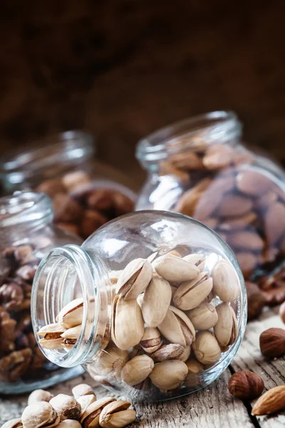 Pistachos salados en un frasco de vidrio, mezcla de nueces —  Fotos de Stock