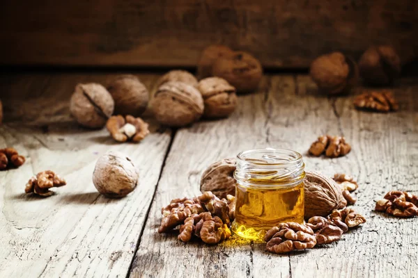 Walnut oil in a small jar and kernels — Stock Photo, Image