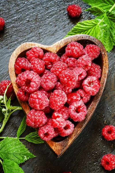 Bowl in the shape of a heart with fresh pink raspberries — Stock Photo, Image