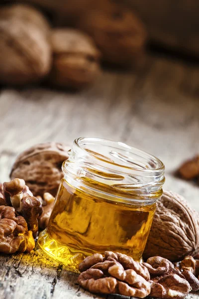 Walnut oil in a small jar and kernels — Stock Photo, Image