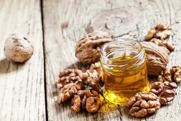 Walnut oil in a small jar and kernels — Stock Photo, Image