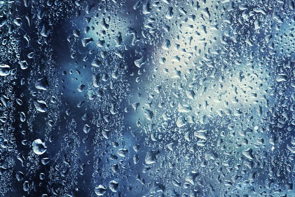 Gotas de lluvia en una ventana en un frío día de invierno — Foto de Stock