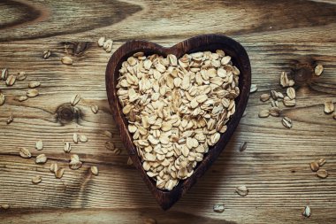 Bir kalp şeklinde ahşap bir kase yulaf gevreği