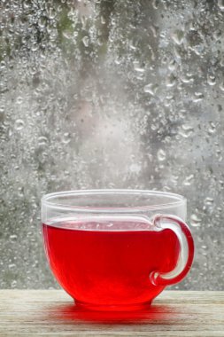 Cup with hot red tea in front of a window  clipart