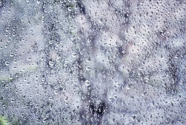 Gotas de lluvia en una ventana en un frío día de invierno — Foto de Stock