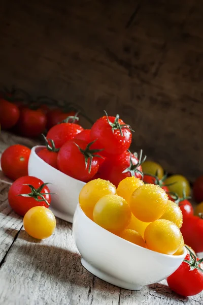 Pomodori ciliegia rossi e gialli in una ciotola di porcellana bianca — Foto Stock