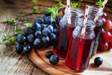 Küçük cam şişelerde karanlık üzüm suyu