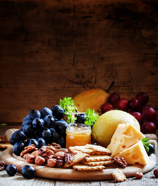 Wooden dish with appetizers to red wine