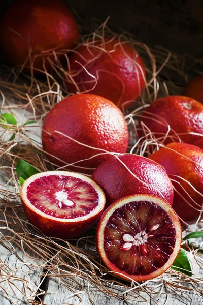 Oranges sanglantes, fruits coupés en deux, paille sèche — Photo