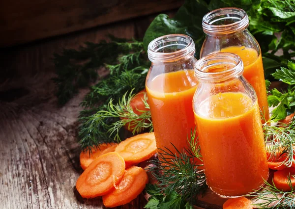 Suco recentemente apertado de cenouras em garrafas de vidro — Fotografia de Stock