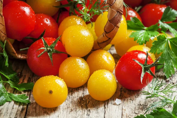 Pomodori ciliegini rossi e gialli fuoriescono da un cesto di vimini — Foto Stock