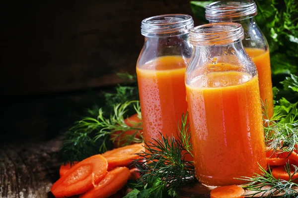 Frisch gepresster Saft von Karotten in Glasflaschen — Stockfoto