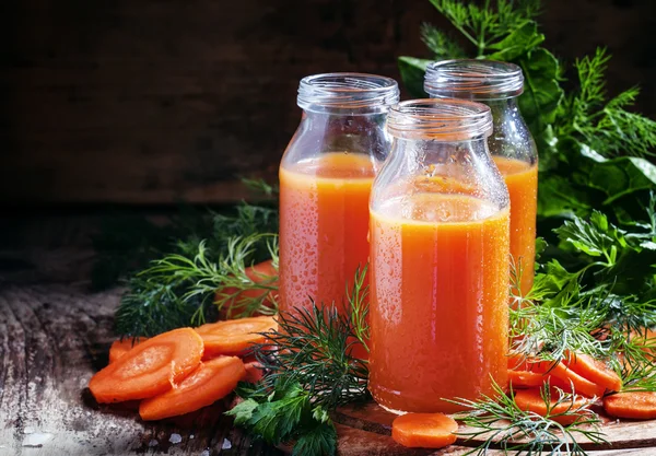 Suco recentemente apertado de cenouras em garrafas de vidro — Fotografia de Stock